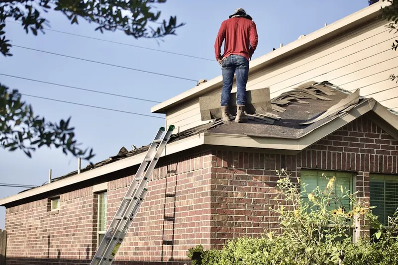 Professional roofer working on a residential roof in Webster Station